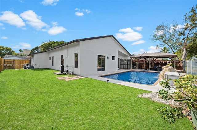 rear view of house with a lawn, a gazebo, a fenced in pool, and a patio