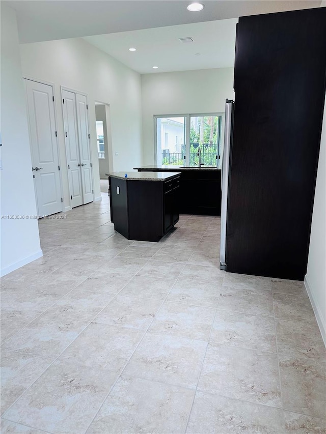 kitchen featuring a kitchen island, sink, and stainless steel fridge