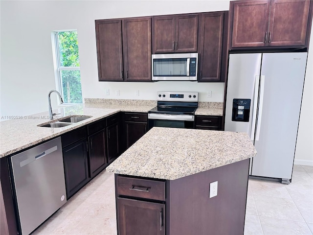 kitchen featuring appliances with stainless steel finishes, light tile patterned floors, sink, and a kitchen island