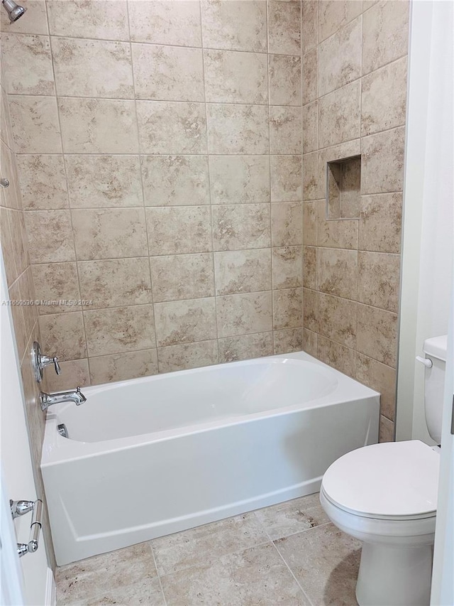 bathroom featuring toilet and tiled shower / bath