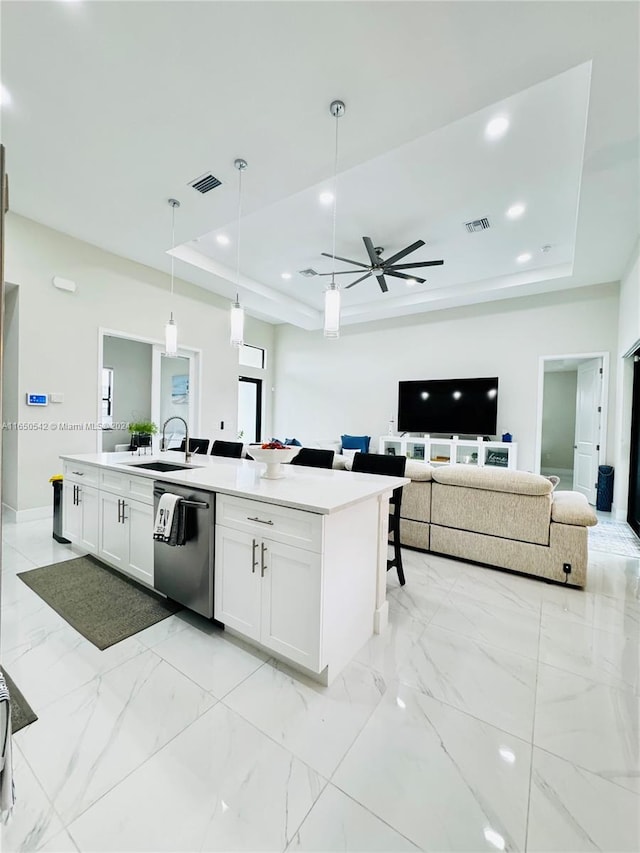 kitchen featuring dishwasher, pendant lighting, white cabinets, and a tray ceiling