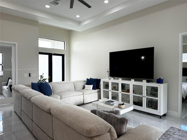 living room featuring ceiling fan and a high ceiling