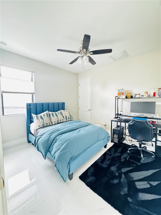 tiled bedroom featuring ceiling fan