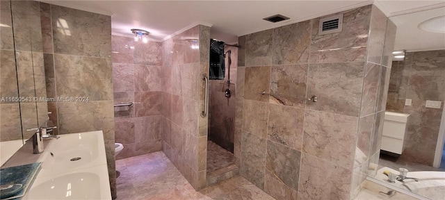 bathroom with tiled shower, vanity, and toilet