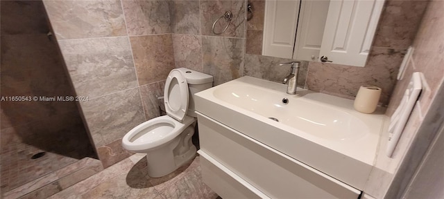 bathroom featuring vanity, toilet, and tile walls