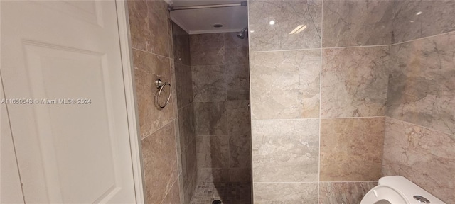 bathroom featuring tiled shower and toilet