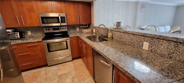 kitchen featuring ornamental molding, stone countertops, tasteful backsplash, sink, and appliances with stainless steel finishes