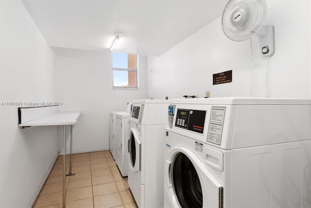 clothes washing area with independent washer and dryer and light tile patterned floors