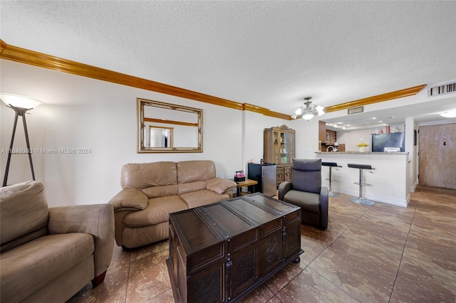 living room with dark tile patterned floors, crown molding, and a textured ceiling