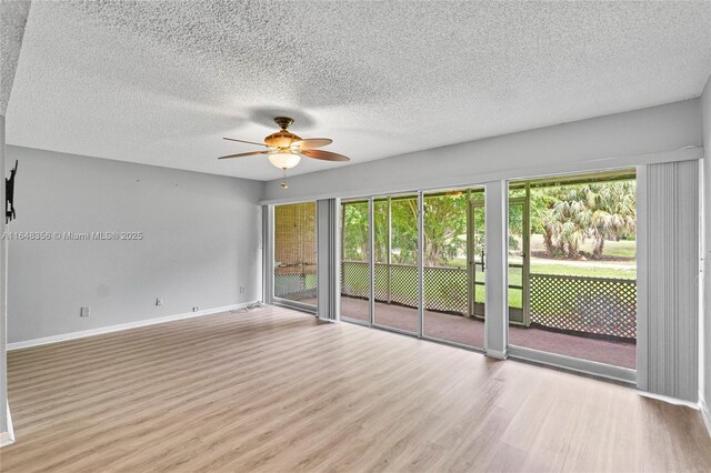 spare room with ceiling fan, a textured ceiling, and light hardwood / wood-style flooring