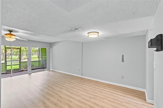 spare room with a textured ceiling, ceiling fan, and light hardwood / wood-style floors