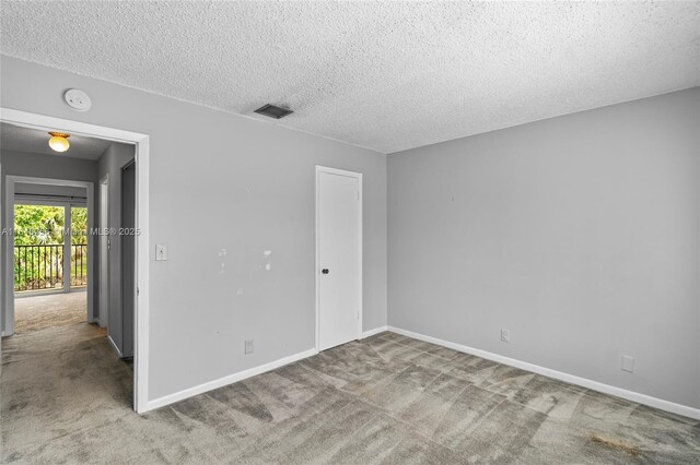 empty room featuring a textured ceiling and carpet floors