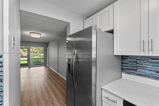 kitchen with stainless steel refrigerator with ice dispenser, backsplash, sink, and light hardwood / wood-style floors