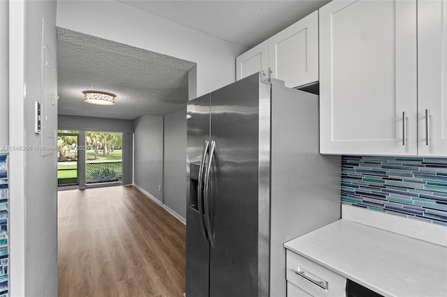 8145 Lagos De Campo Blvd Unit D-1, Tamarac, FL 33321 - kitchen featuring stainless steel refrigerator with ice dispenser, white cabinets, backsplash, wood finished floors, and a textured ceiling