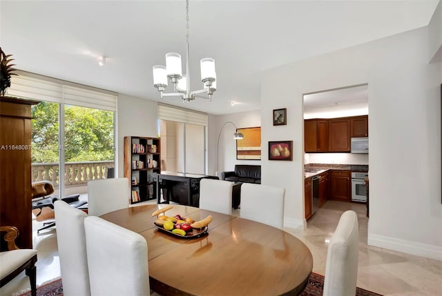 tiled dining room featuring an inviting chandelier