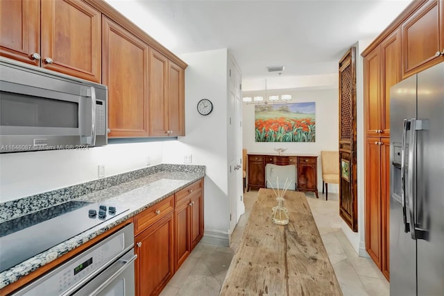 kitchen featuring light stone counters, light tile patterned floors, and stainless steel appliances