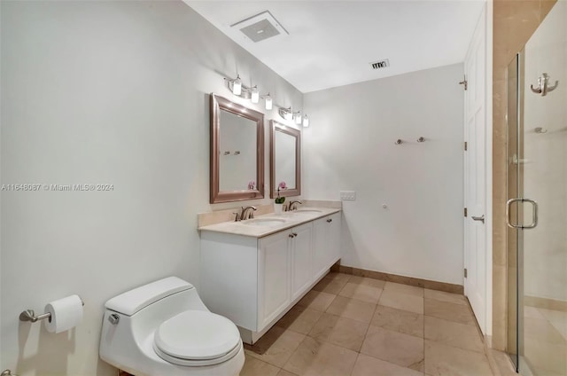 bathroom with tile patterned floors, vanity, an enclosed shower, and toilet