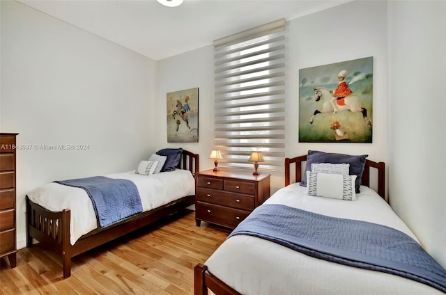 bedroom with multiple windows and light hardwood / wood-style floors