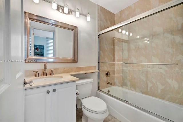 full bathroom featuring tile patterned floors, toilet, vanity, and combined bath / shower with glass door