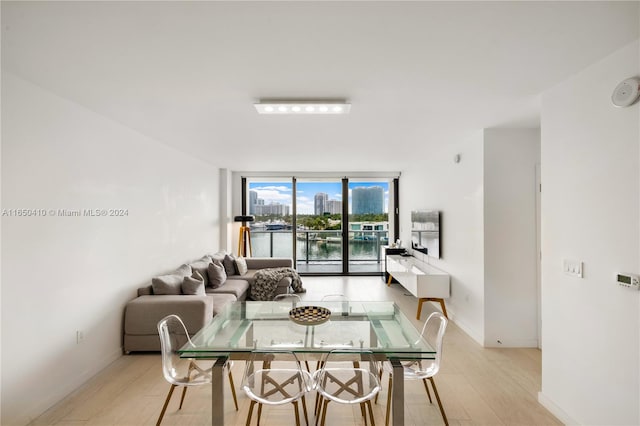 dining space featuring light wood-type flooring and a water view