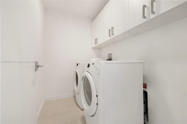 laundry area featuring washing machine and clothes dryer and cabinets