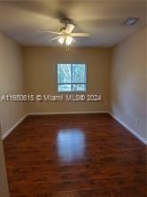 empty room featuring ceiling fan and dark hardwood / wood-style floors