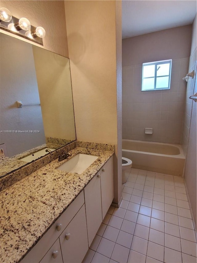 full bathroom featuring tiled shower / bath combo, vanity, toilet, and tile patterned flooring