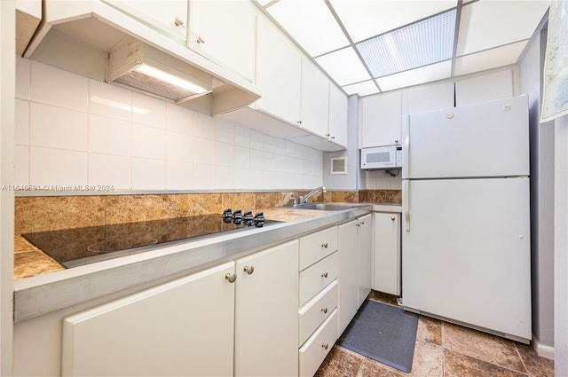 kitchen featuring white appliances, tasteful backsplash, sink, premium range hood, and white cabinets