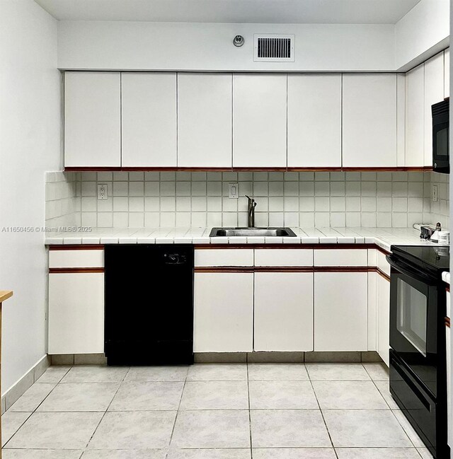 kitchen with white cabinetry, sink, decorative backsplash, and black appliances