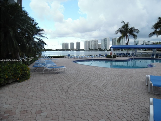 view of swimming pool with a water view and a patio area