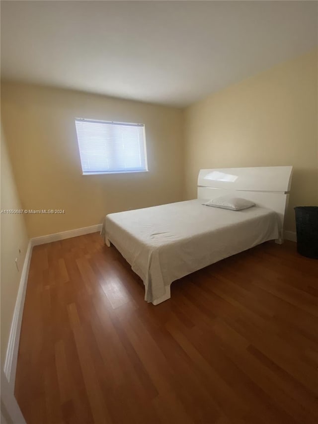 unfurnished bedroom with dark hardwood / wood-style flooring