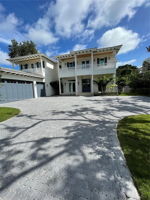 view of front of property featuring a balcony, french doors, and a garage