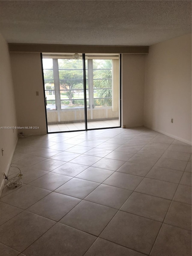 tiled spare room with a textured ceiling