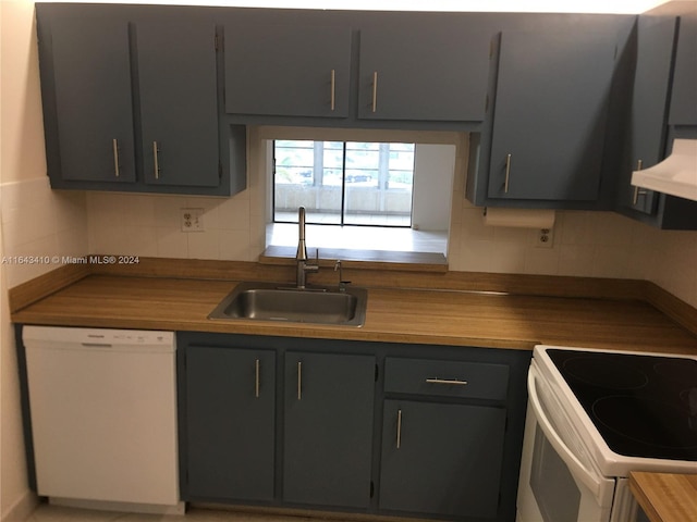 kitchen featuring gray cabinetry, backsplash, sink, and white appliances