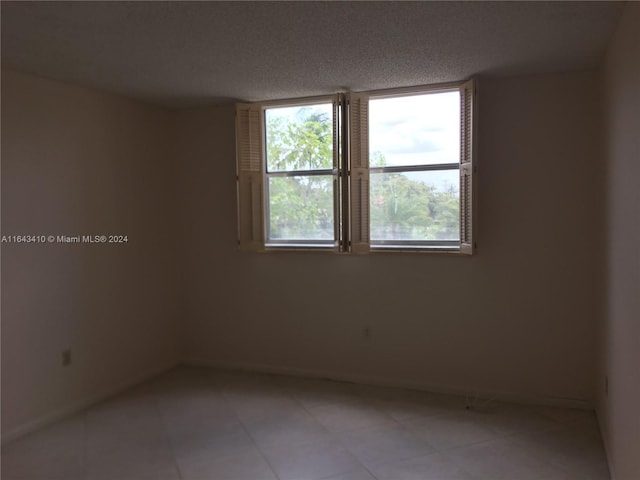 unfurnished room with a textured ceiling