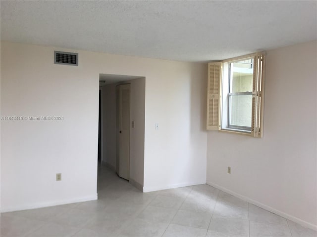 unfurnished room featuring a textured ceiling