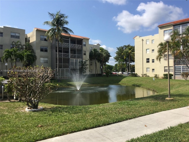 view of property's community with a water view and a yard