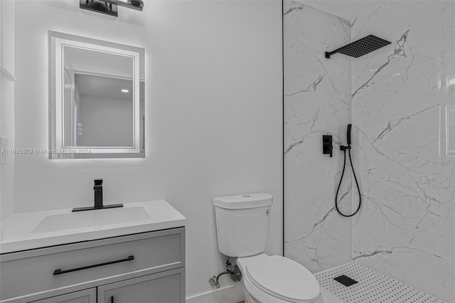 bathroom with toilet, vanity, and tiled shower