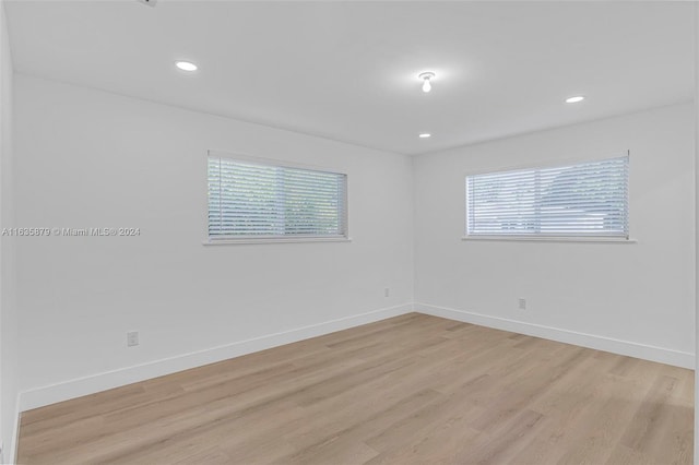 empty room with light hardwood / wood-style flooring and a healthy amount of sunlight