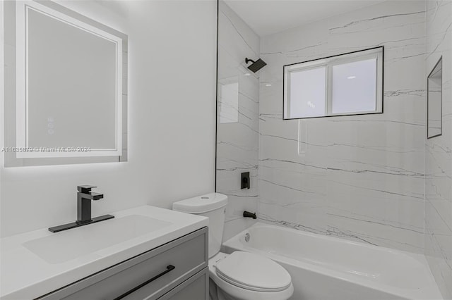 full bathroom featuring vanity, tiled shower / bath, and toilet