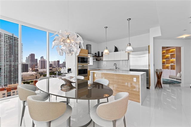 dining room with light tile patterned floors, a notable chandelier, and sink