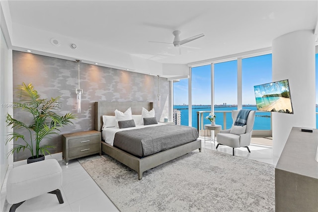 bedroom featuring light tile patterned floors, access to exterior, ceiling fan, and a wall of windows