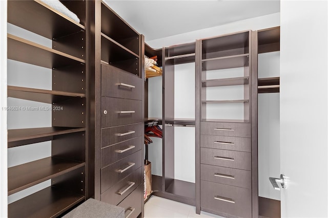 walk in closet with light tile patterned floors