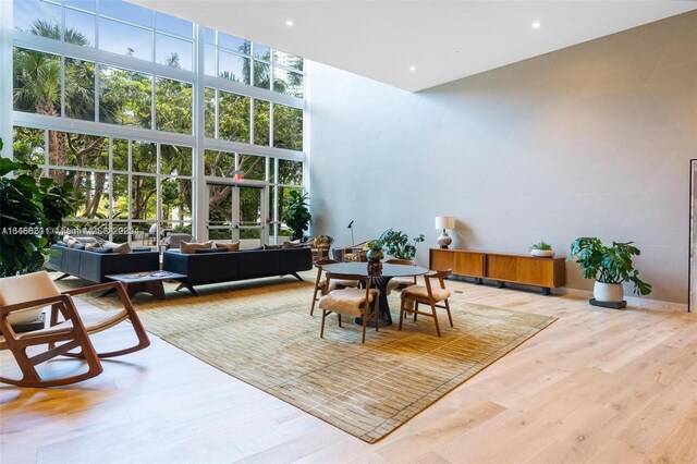 living room featuring a high ceiling, light wood-type flooring, and a chandelier