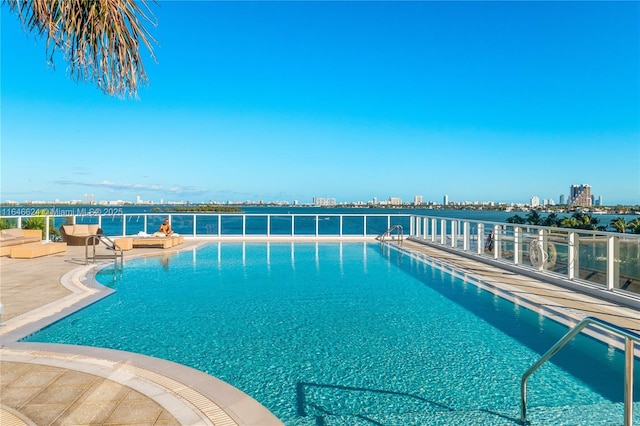 view of swimming pool featuring a water view