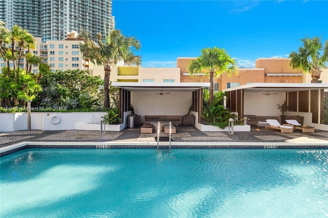 view of swimming pool with an outdoor living space, a patio, and ceiling fan