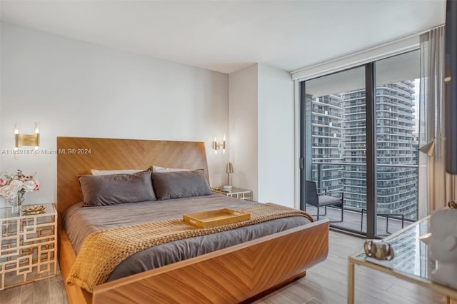 bedroom with access to exterior, hardwood / wood-style floors, and floor to ceiling windows