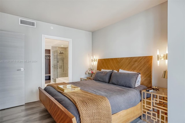 bedroom with connected bathroom and wood-type flooring