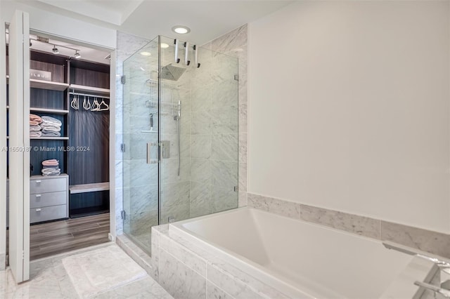 bathroom with shower with separate bathtub and wood-type flooring