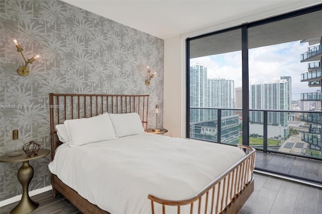 bedroom with hardwood / wood-style flooring, expansive windows, and multiple windows